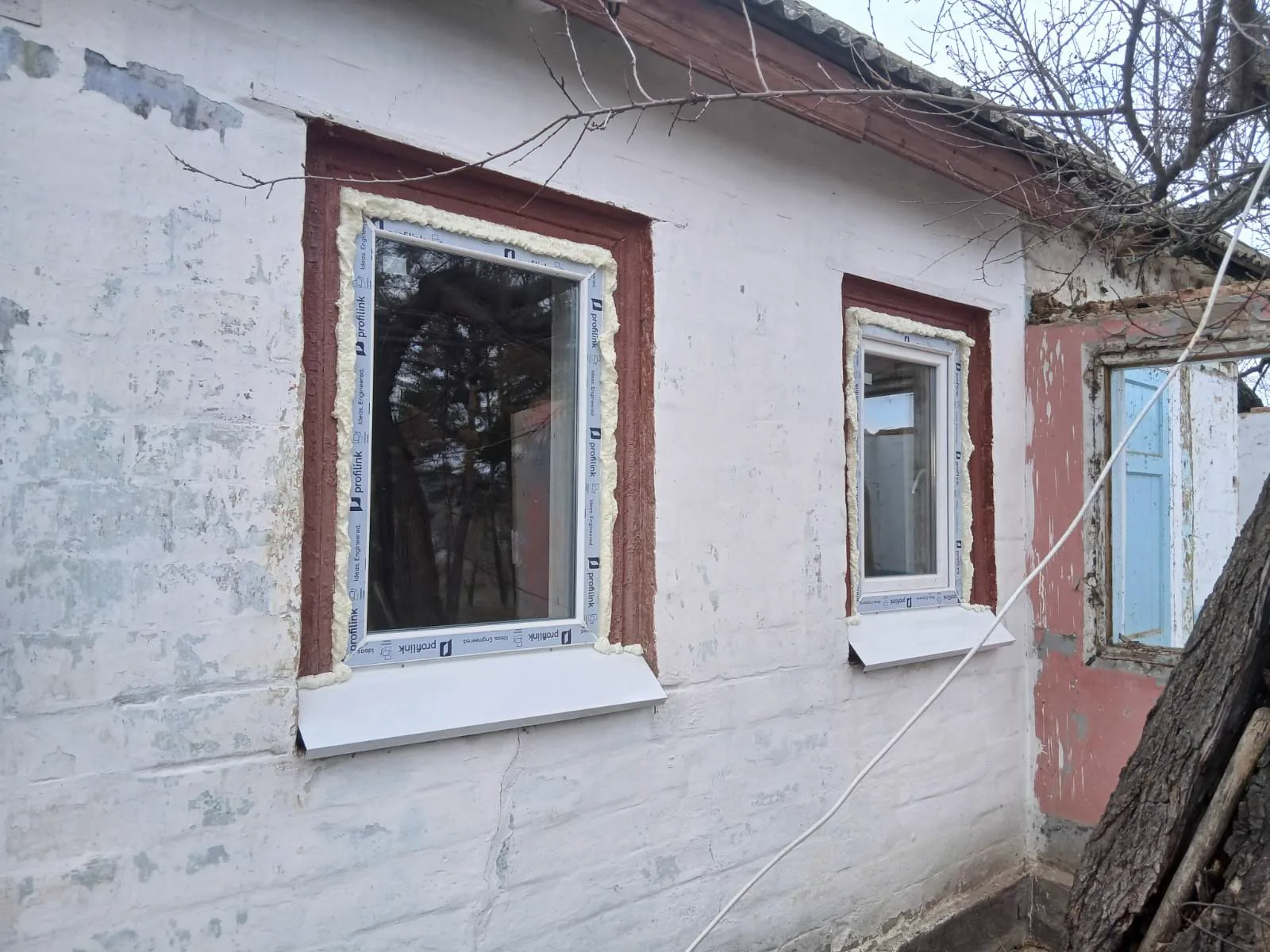 Нові білі вікна на фасаді приватного будинку
